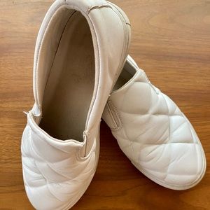 Slip on white vegan faux leather women’s walking shoes with rubber soles.